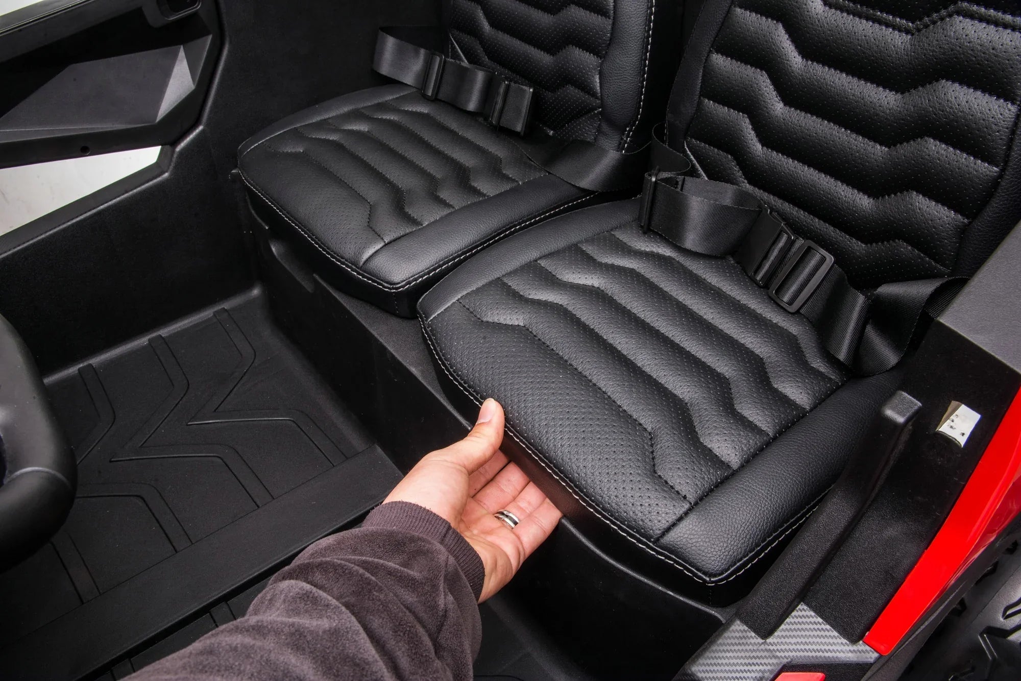 Close-up of black adjustable leather dual seats with seatbelts inside the Stinger Buggy XL kids ride-on car.