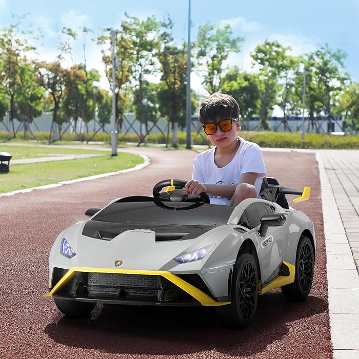 Child riding a grey Licensed Lamborghini Huracán STO 24V kids drift car with remote control on a track outdoors