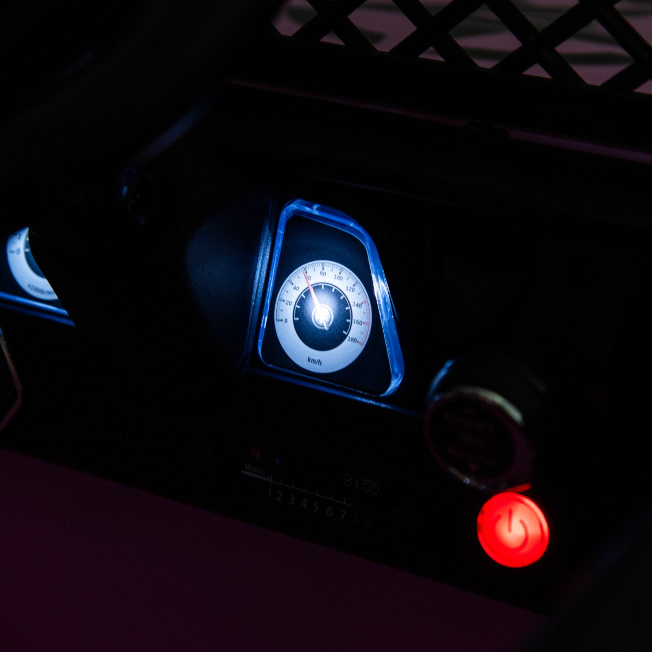 Close-up of the illuminated speedometer and red power button on the Toyota FJ Cruiser pink electric toy car console.
