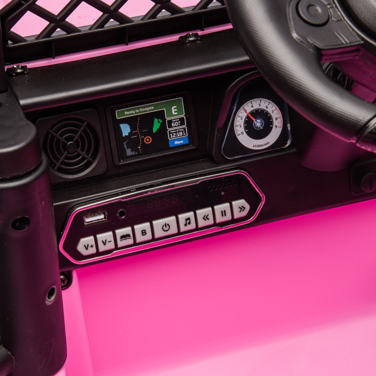 Close-up of the pink Toyota FJ Cruiser kids electric car dashboard with music and volume controls and steering wheel.