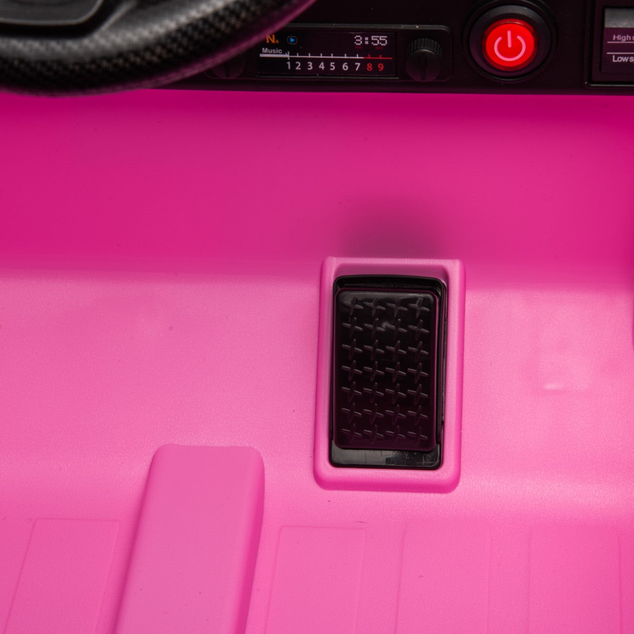 Close-up of the black accelerator pedal on the pink Toyota FJ Cruiser 12V electric ride-on toy car for kids.