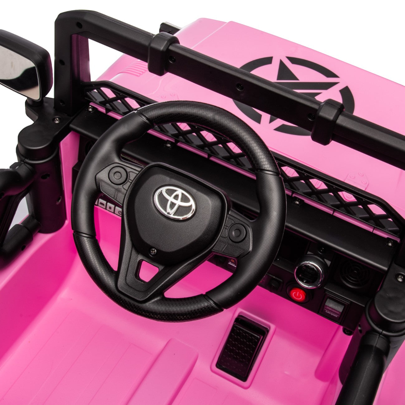 Close-up of the steering wheel and dashboard of the pink Toyota FJ Cruiser electric ride-on toy car for kids.