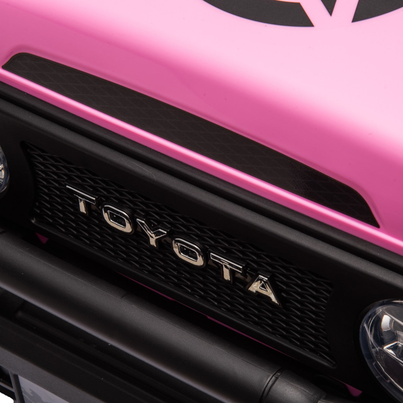 Close-up of the front grille and headlights of a pink Toyota FJ Cruiser licensed electric ride-on toy car for kids