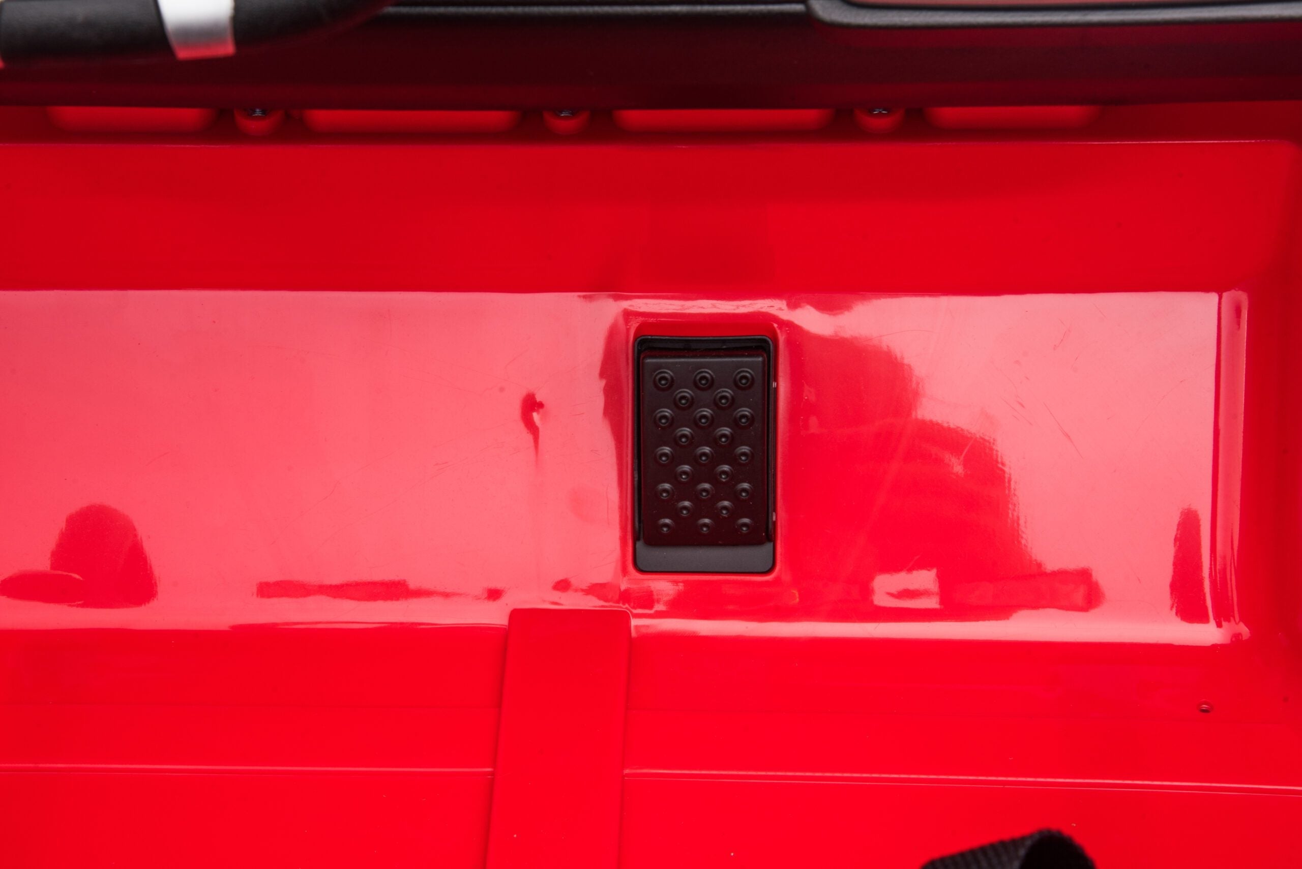 Close-up of the accelerator pedal on a red Toyota FJ40 LandCruiser 24V kids ride-on SUV.