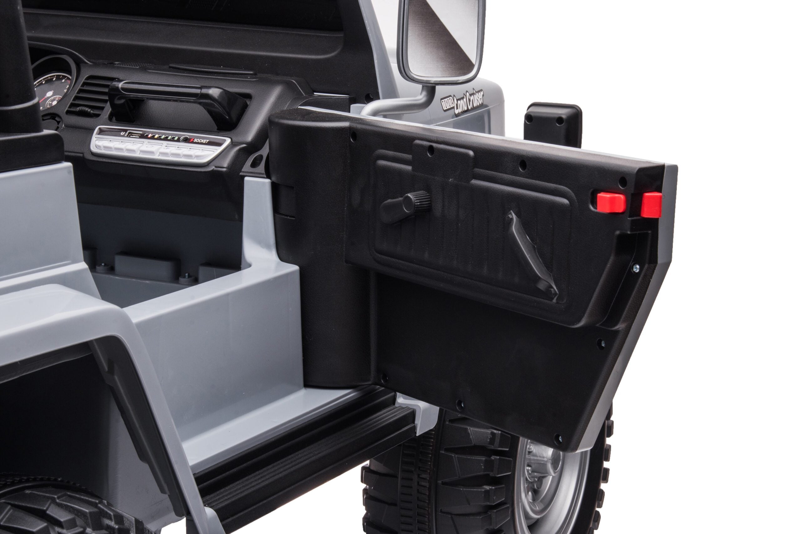 Close-up of open black door and interior of Licensed Toyota FJ-40 kids red ride-on SUV showing dashboard and wheel.