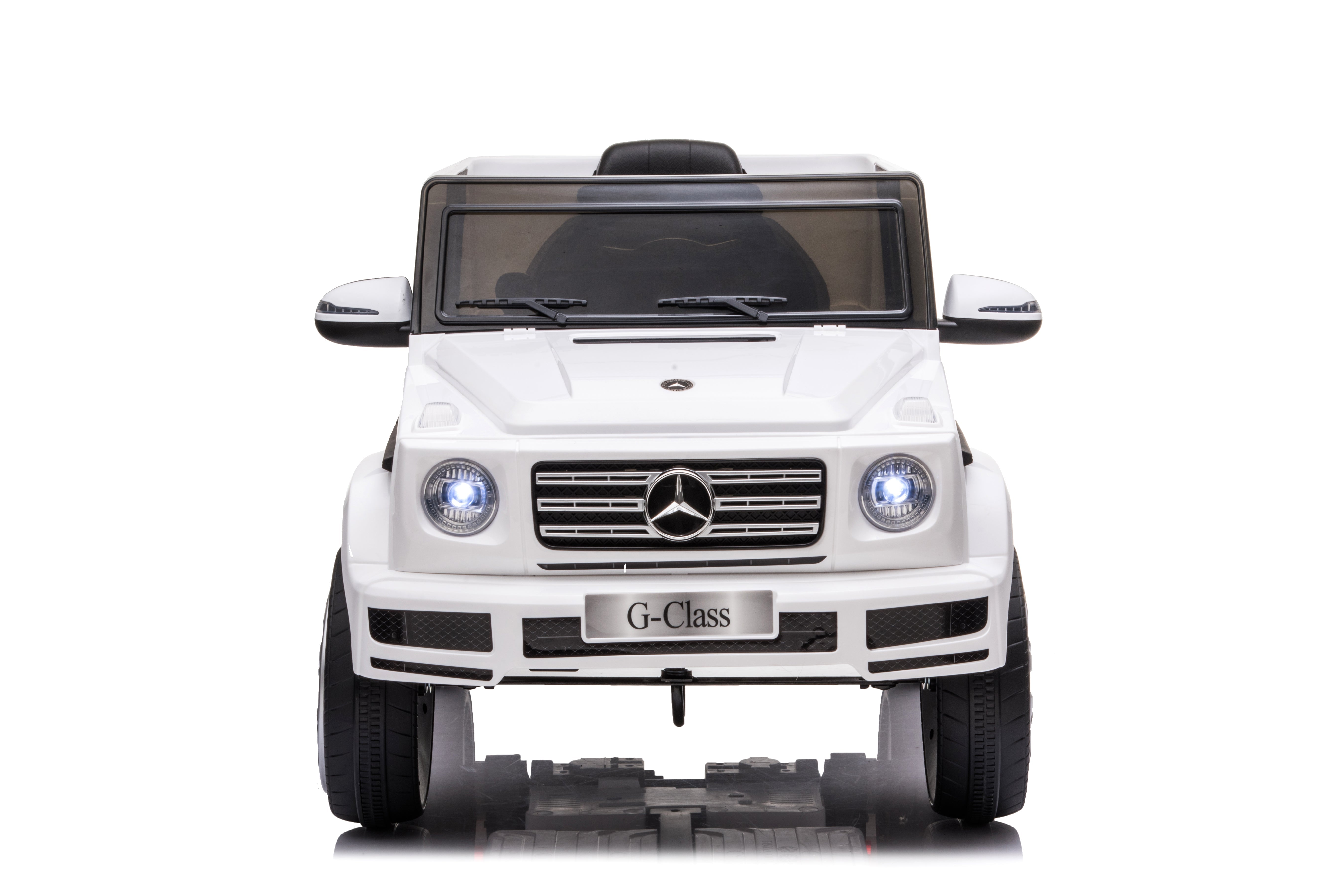 Front view of white 12V licensed Mercedes G-Class G63 kids electric ride-on car with headlights on against white background