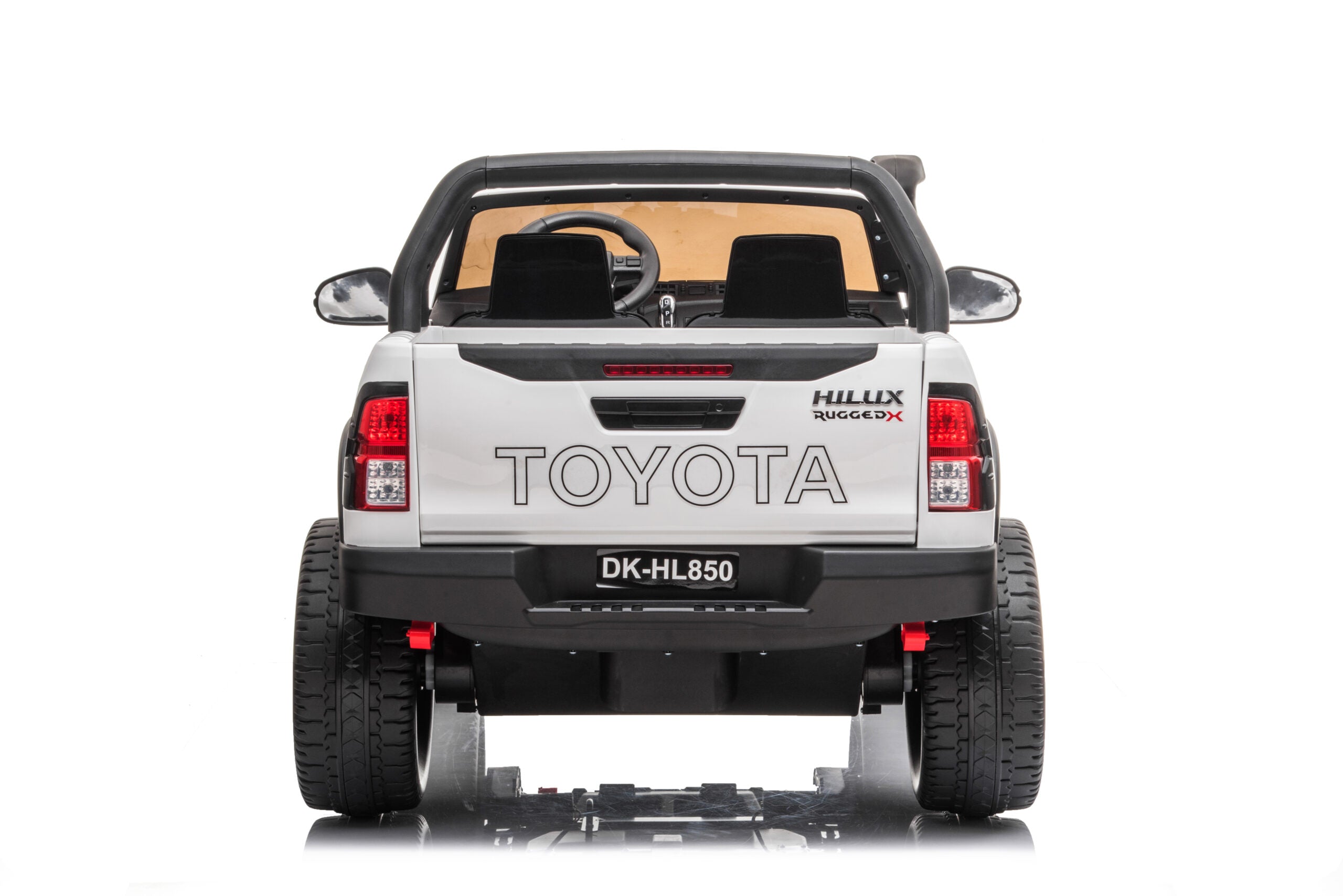 Rear view of a white Licensed Toyota Hilux Rugged 24V kids electric ride-on car with two seats and off-road tires.