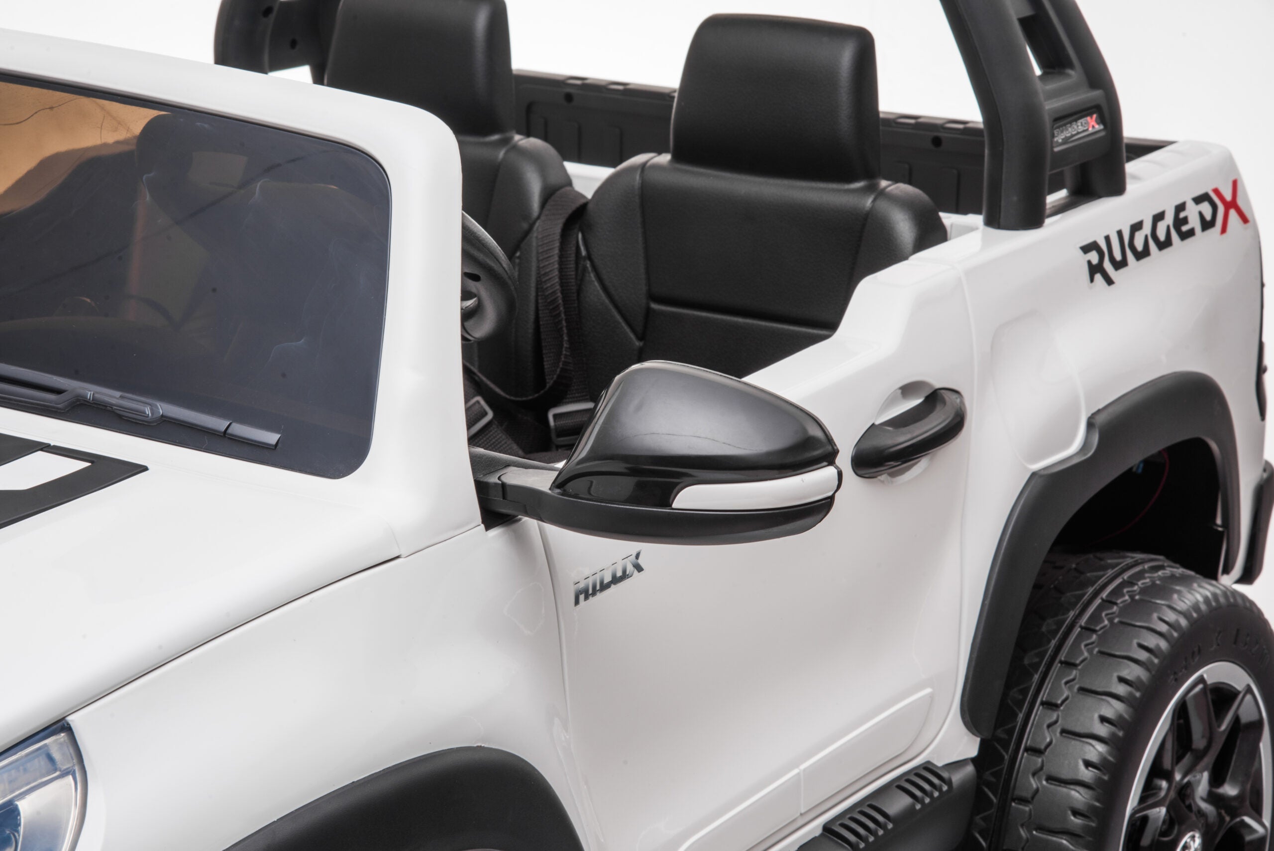 White Licensed Toyota Hilux Rugged 24V Kids Ride-On Car with black leather seats and detailed side mirror close-up