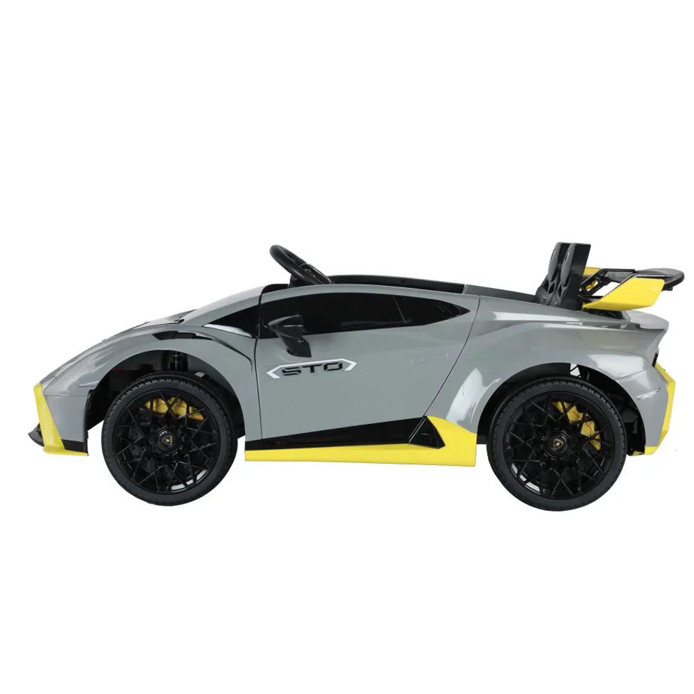 Grey Licensed Lamborghini Huracán STO 24V kids electric drift car with black wheels and yellow accents side view