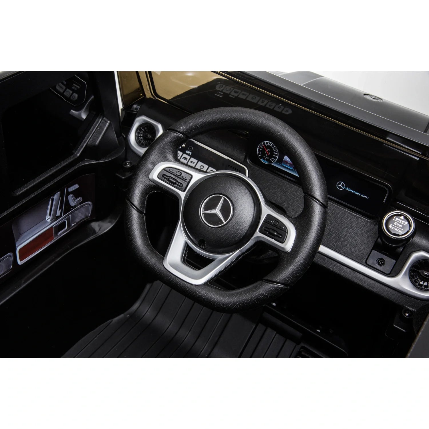 Close-up of black steering wheel with Mercedes logo and dashboard inside kids electric 12V ride-on G-Wagon car
