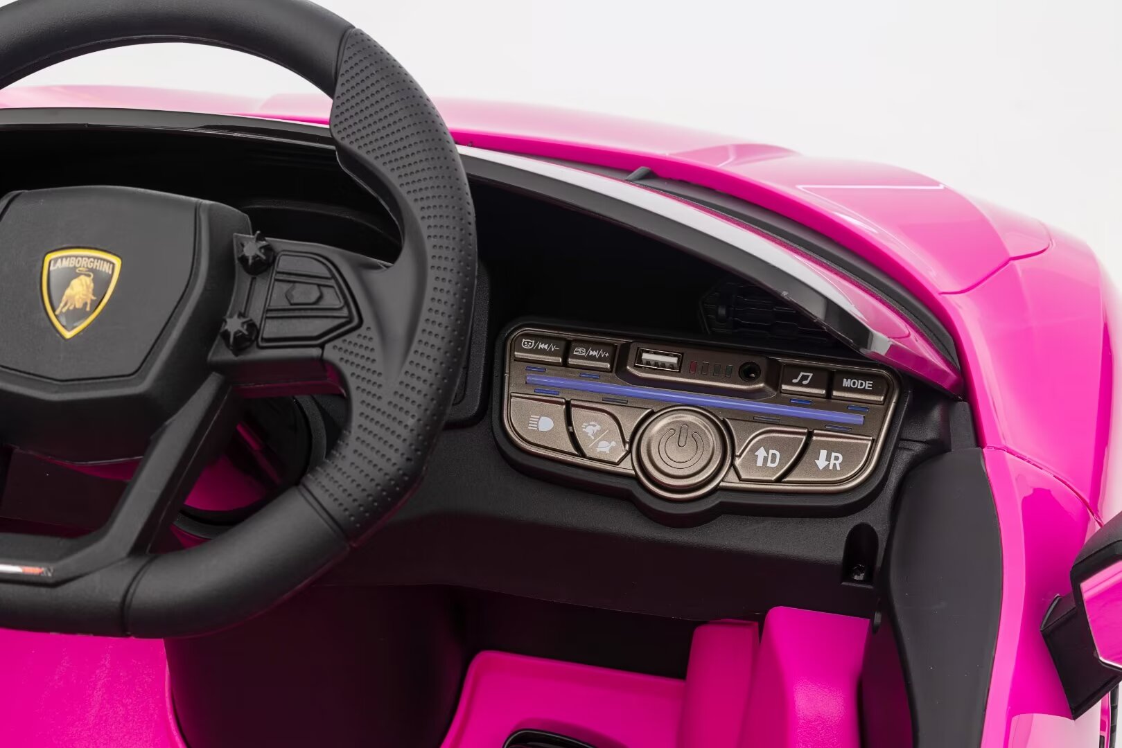 Close-up of a pink Lamborghini Revuelto 12V kids ride-on car dashboard with steering wheel and control panel features.