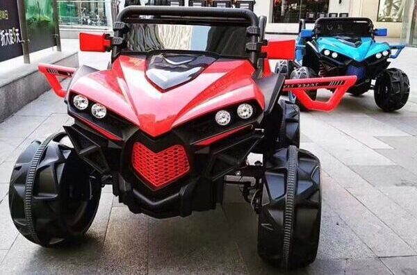 12V 4WD kids ride-on monster truck buggy in red and blue with chunky off-road tyres and sporty design.