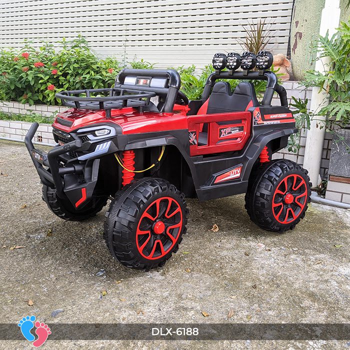 Red Monster Truck UTV 4WD kids ride-on buggy with chunky wheels and off-road design parked outdoors